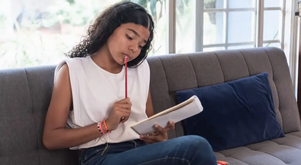 A teenage girl implements strategies to help with ADHD while doing homework.