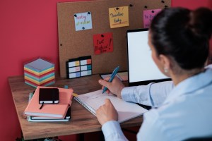 Woman with ADHD organizing reminders to mange forgetfulness and executive functioning.